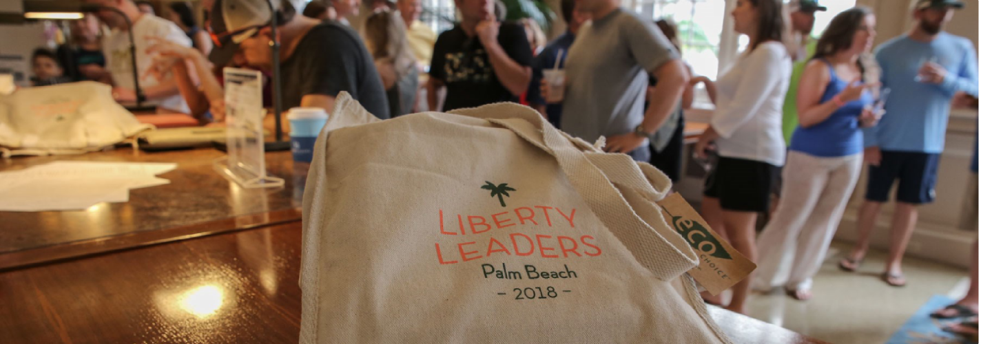 liberty leaders canvas tote bag in foreground; people socializing at background