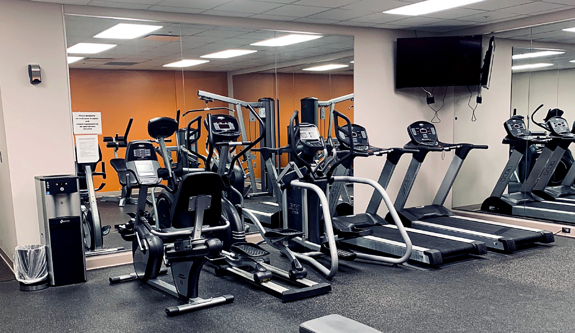 treadmills, elliptical and television inside fitness center